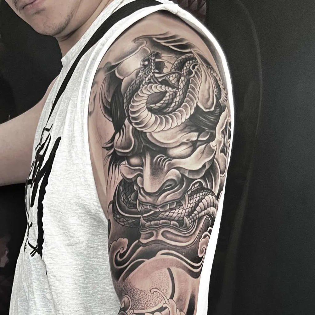 a black and grey tattoo on upper arm